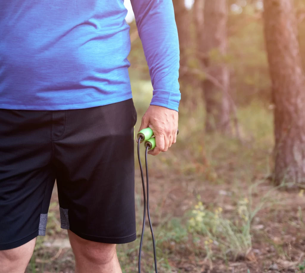 adult man in blue clothes holding a jump rope for utc