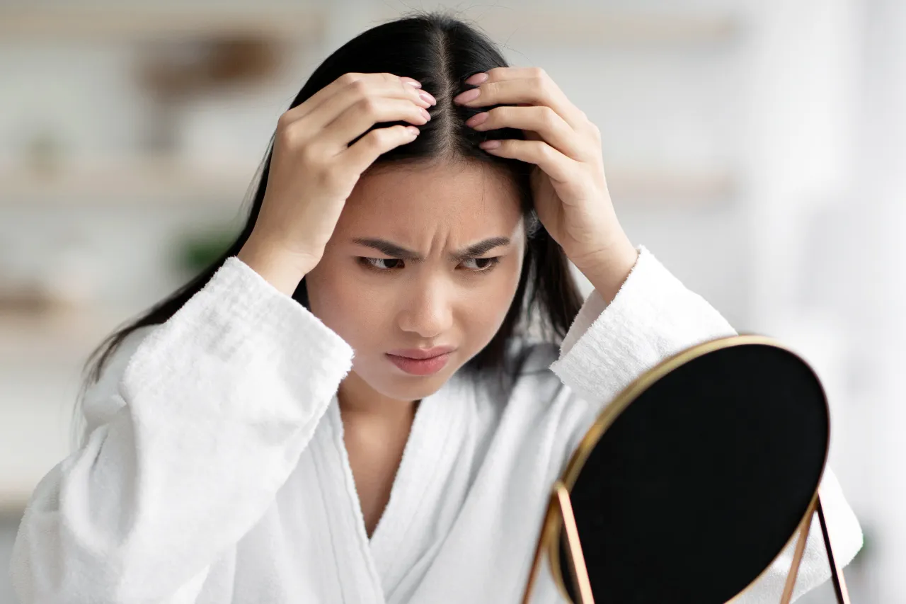 angry asian lady checking her grey hair utc